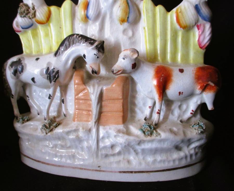 A Victorian Staffordshire spill, a cow and horse drinking from a trough beneath birds. Chip. 25x16cm