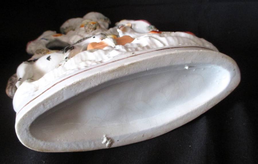 A Victorian Staffordshire spill, a cow and horse drinking from a trough beneath birds. Chip. 25x16cm