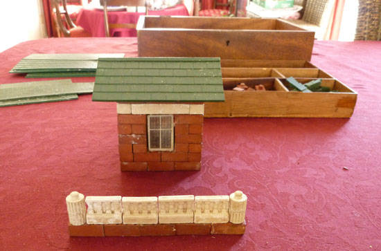 A walnut box containing a large collection of mini-bricks