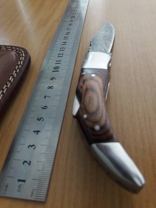 Handmade Damascus steel folding knife with Wooden handle scales.