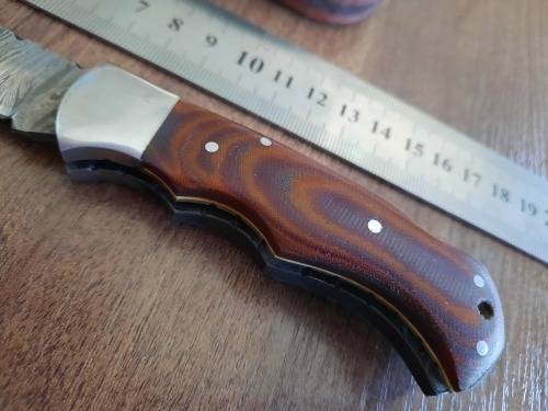 Handmade Damascus steel folding knife with MICARTA handle scales.