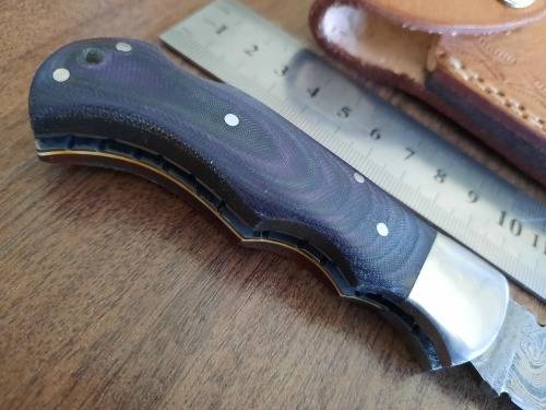 Handmade Damascus steel folding knife with MICARTA handle scales.
