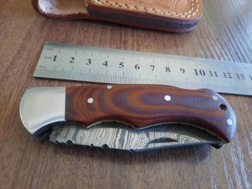 Handmade Damascus steel folding knife with MICARTA handle scales.