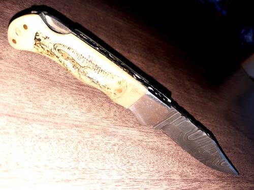 Handmade Damascus steel folding knife w Camel Bone Handle Scales. Art engraved.