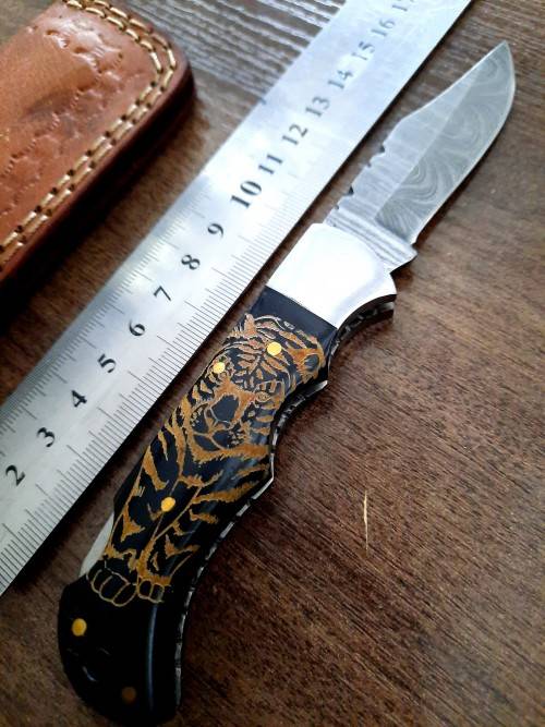 Handmade Damascus steel folding knife with Bull Horn Handle. Tiger picture engraved.