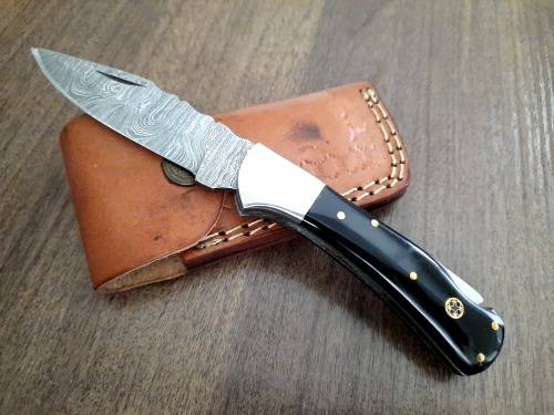 Handmade Damascus steel folding knife with Epoxy Resin handle scales. Leather pouch included.