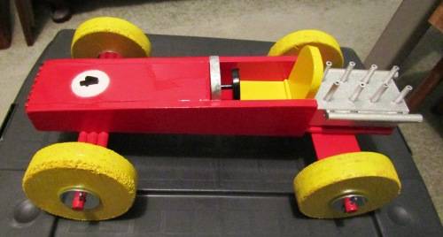 LARGE HAND MADE WOODEN `F1 RACING CAR` IN RED WITH YELLOW WHEELS. TOUGH STRUCTURE. NOT DINKY.