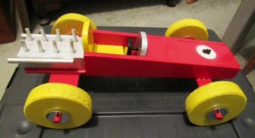 LARGE HAND MADE WOODEN `F1 RACING CAR` IN RED WITH YELLOW WHEELS. TOUGH STRUCTURE. NOT DINKY.