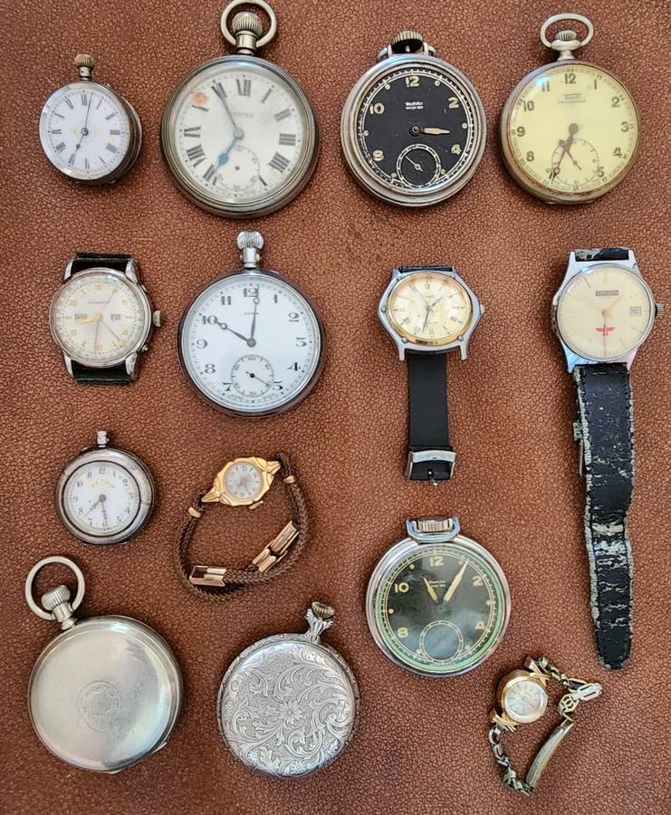 Old tin box full of watches  pocket watches, coins and pins