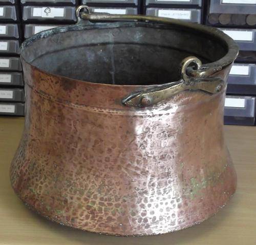 Large hand-made copper pot with heavy brass handle, bottom well used, with small crack