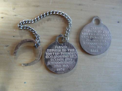 Pair of rare United Tobacco Johannesburg key tokens, numbered - one with chain and horseshoe