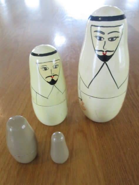 AN UNUSUAL FOUR PIECE HAND PAINTED MATRYOSHKA/BABUSHKA NESTING DOLL SET