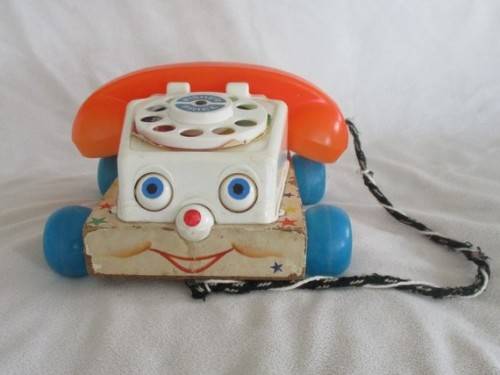 A VINTAGE 1960's FISHER PRICE PULL ALONG TELEPJONE WITH WOODEN BASE