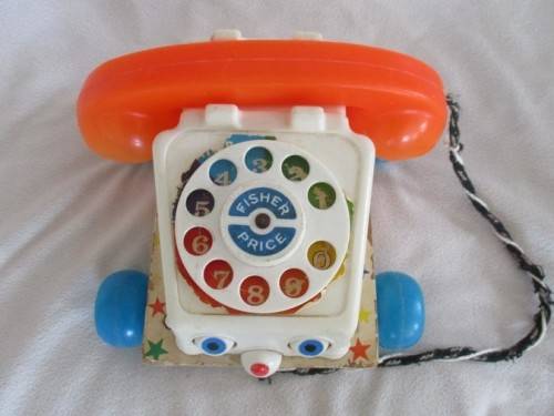 A VINTAGE 1960's FISHER PRICE PULL ALONG TELEPJONE WITH WOODEN BASE