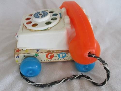 A VINTAGE 1960's FISHER PRICE PULL ALONG TELEPJONE WITH WOODEN BASE