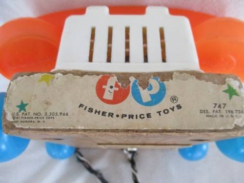 A VINTAGE 1960's FISHER PRICE PULL ALONG TELEPJONE WITH WOODEN BASE