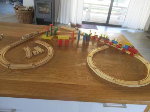 A BAG FULL OF VINTAGE WOODEN TOYS INCLUDING TWO LOCOMOTIVES WITH CARRIAGES, TRACKS AND WOODEN BLOCKS