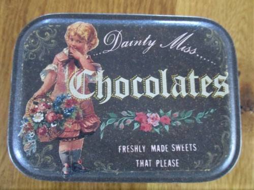 A VINTAGE "DAINTY MISS CHOCOLATES" TIN FILLED WITH OVER A HUNRED OLD 1/2 CENT COINS (LARGER SIZE)