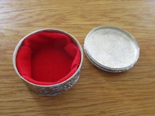 VERY DECORATIVE SILVER METAL TRINKET BOX WITH RED VELVET LINING (PLEASE DISREGARD REFLECTIONS)