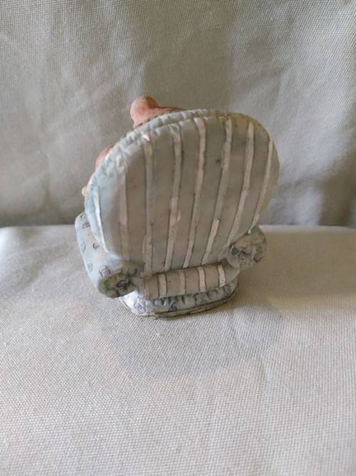 Teddy bear in blue armchair talking on the telephone