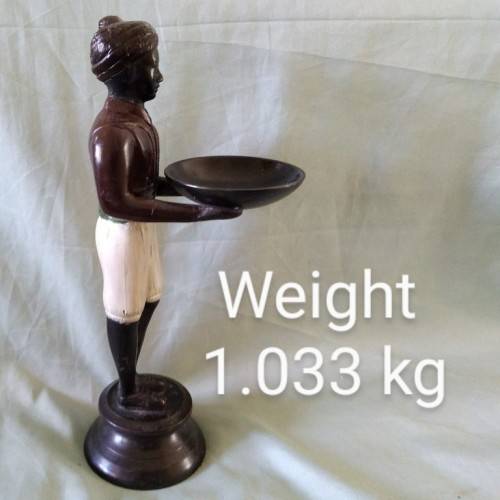 Decorative metal statuette of man holding a bowl