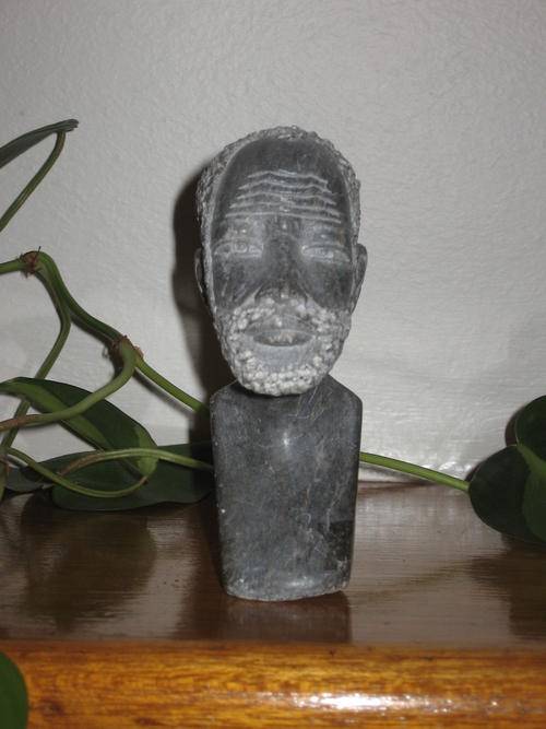 The "bust" of a Xhosa appears to be made of granite.  Carved with intricate detail