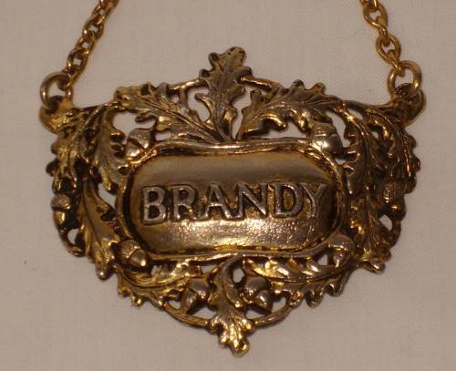 VINTAGE BRASS-PLATED BRANDY DECANTER LABEL