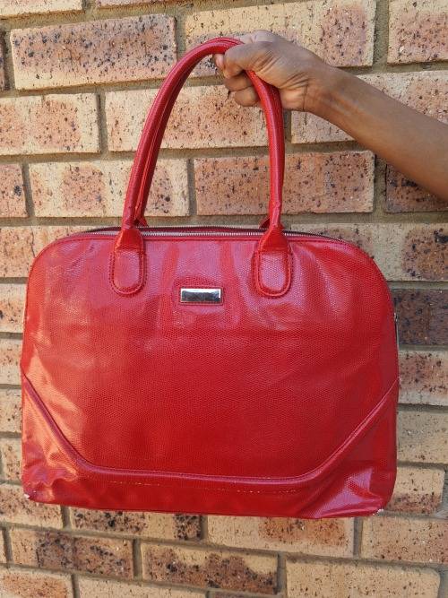A RED TOTE HAND BAG MADE BY BARON
