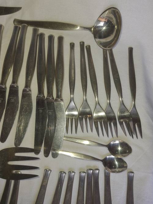 A VINTAGE STAINLESS STELL CUTTLERY SET SOLD AS IS
