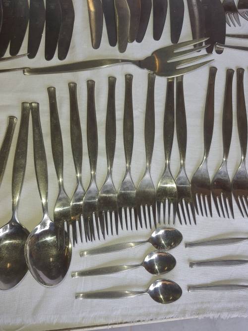 A VINTAGE STAINLESS STELL CUTTLERY SET SOLD AS IS
