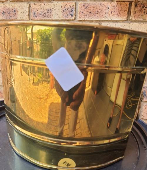 A BRASS VINTAGE PLANTER WITH LION HEAD HANDLES SOLD AS IS