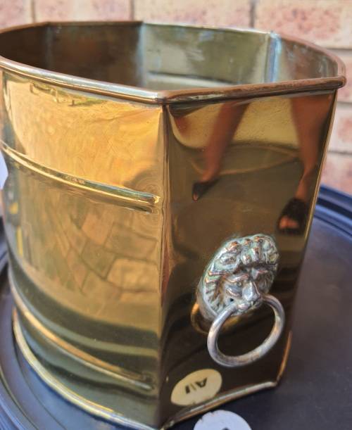 A BRASS VINTAGE PLANTER WITH LION HEAD HANDLES SOLD AS IS