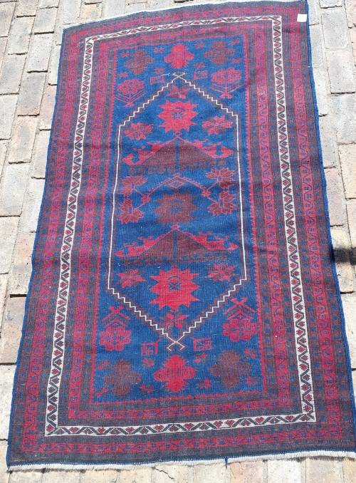 A BEAUTIFUL RED AND BLUE PERSIAN RUG