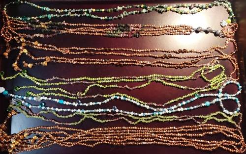 A COLLECTION OF MULTI COLOURED EXTRA LENGTH PEARL NECKLACES SOLD AS IS