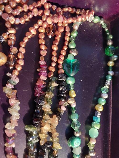 A COLLECTION OF MULTI COLOURED EXTRA LENGTH PEARL NECKLACES SOLD AS IS