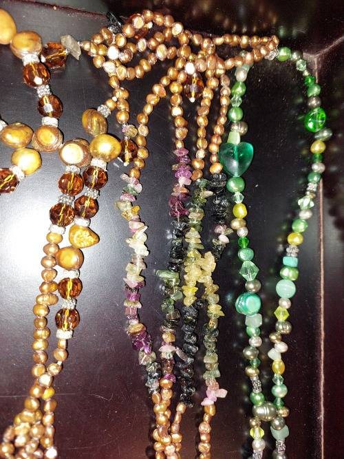 A COLLECTION OF MULTI COLOURED EXTRA LENGTH PEARL NECKLACES SOLD AS IS