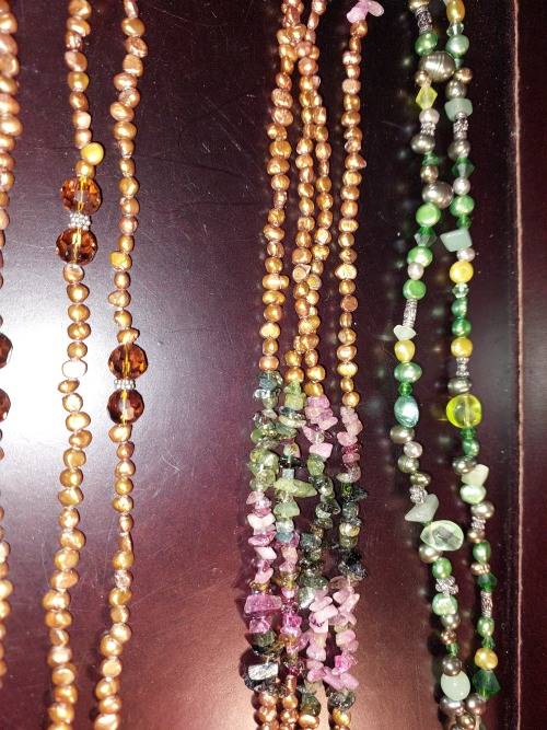 A COLLECTION OF MULTI COLOURED EXTRA LENGTH PEARL NECKLACES SOLD AS IS