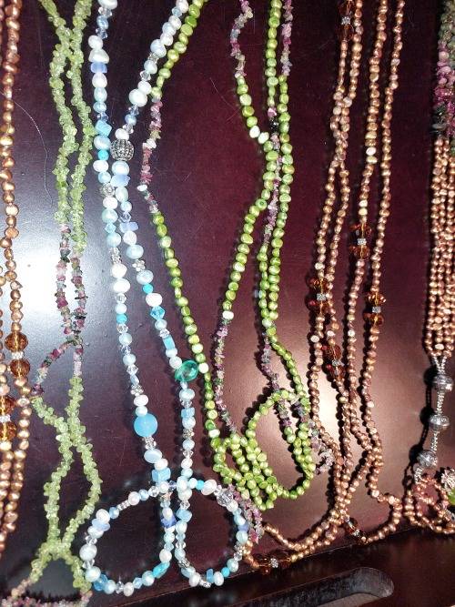 A COLLECTION OF MULTI COLOURED EXTRA LENGTH PEARL NECKLACES SOLD AS IS