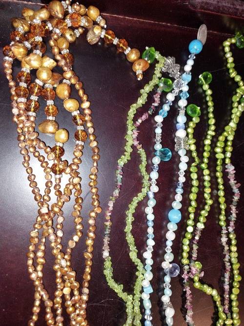 A COLLECTION OF MULTI COLOURED EXTRA LENGTH PEARL NECKLACES SOLD AS IS