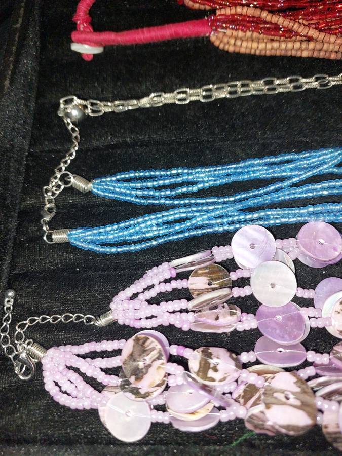 A COLLECTION OF DENSE MULTI STRAND NECKLACES SOLD AS IS