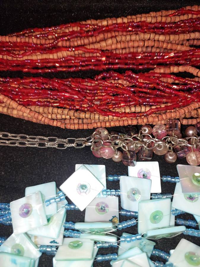 A COLLECTION OF DENSE MULTI STRAND NECKLACES SOLD AS IS