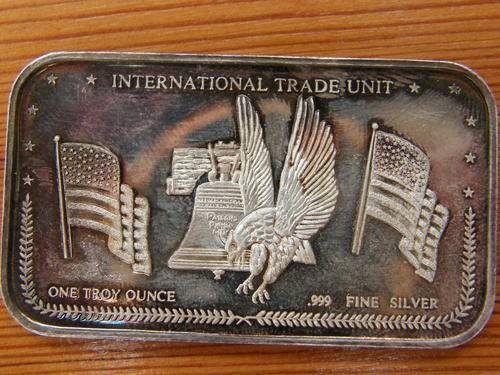A VERY INTERESTING ONE OUNCE 999 FINE SILVER INTERNATIONAL TRADE UNIT BAR