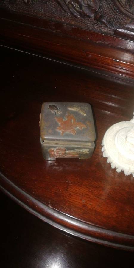 An ivory carved miniature figure and metal box