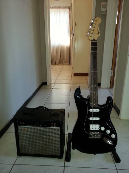 Squier "Bullet" Strat with 20W amplifier, guitar pedal and cable.