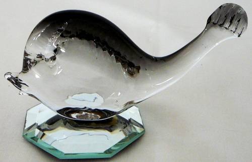 A Murano Glass Whale resting on an Octagonal Mirror