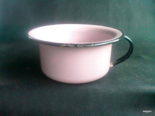 ENAMEL PINK AND BLACK CHAMBER POT. PLEASE NOTE:BURN MARK. AND SCRATCHES ON LIP.