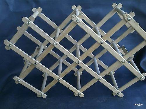 8 BOTTLE WINE RACK. FOLDS UP. ENDS ARE DAMAGED. ONE GOLD ATTACHMENT MISSING. SIDE PART LOOSE.