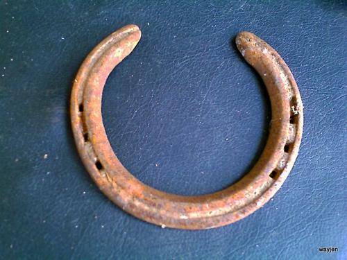 SOLID STEEL HORSESHOE. HORSESHOES ARE BELIEVED TO BE PROTECTORS OF BUILDINGS. THESE ARE WELL WORN.