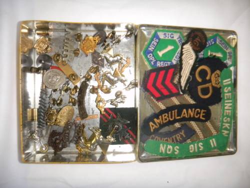 Assorted Military Badges and Insignia in collectible tin