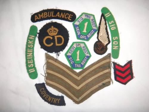 Assorted Military Badges and Insignia in collectible tin